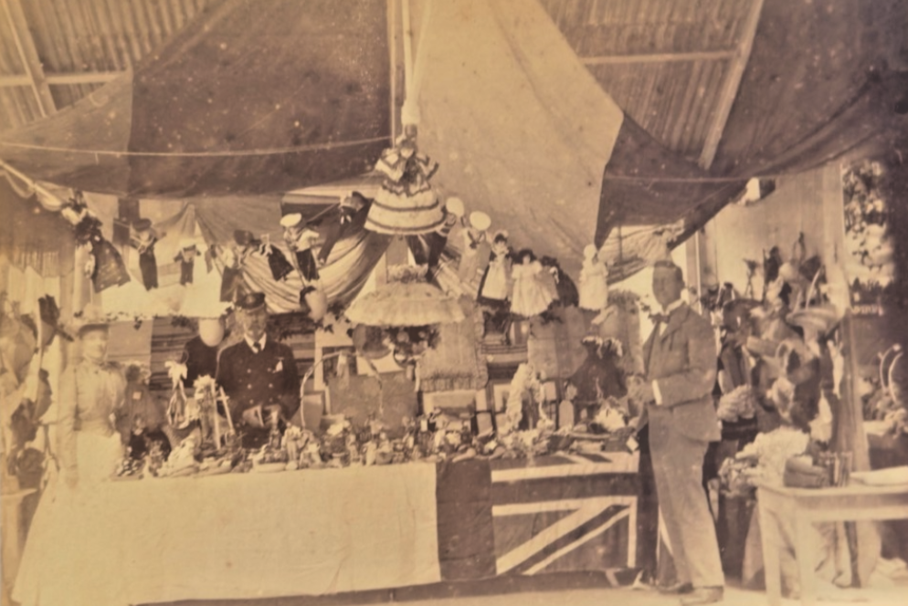 Vintage photograph of a decorated interior with people and a large flag, possibly from an event or celebration.