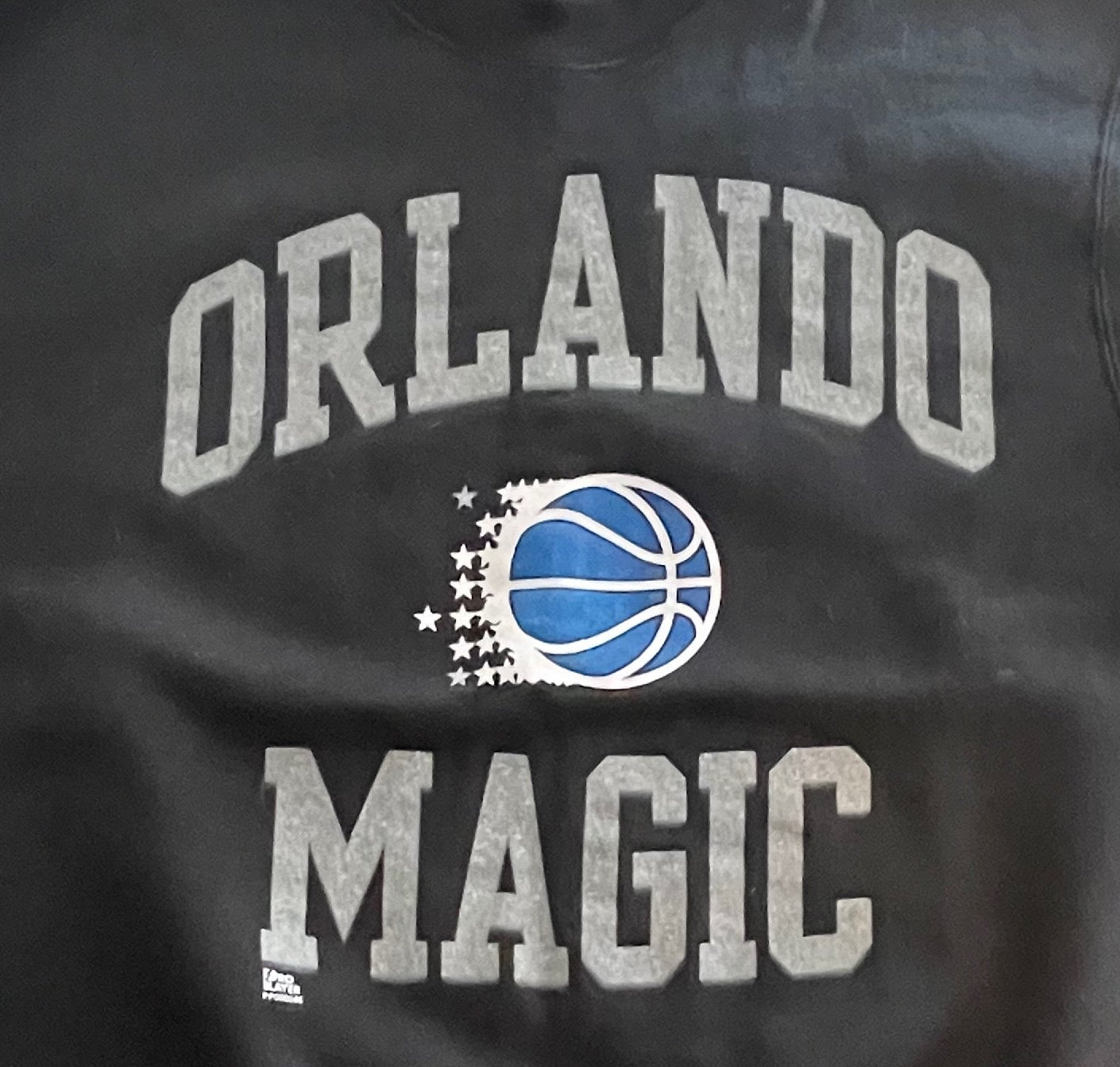 Black Orlando Magic sweatshirt on a wooden surface