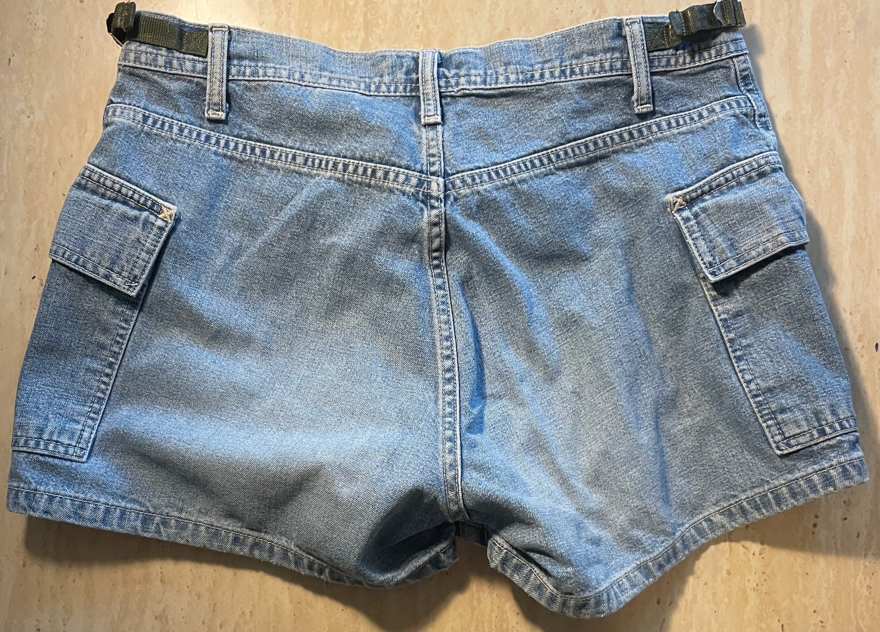 Pair of blue denim shorts on a wooden surface