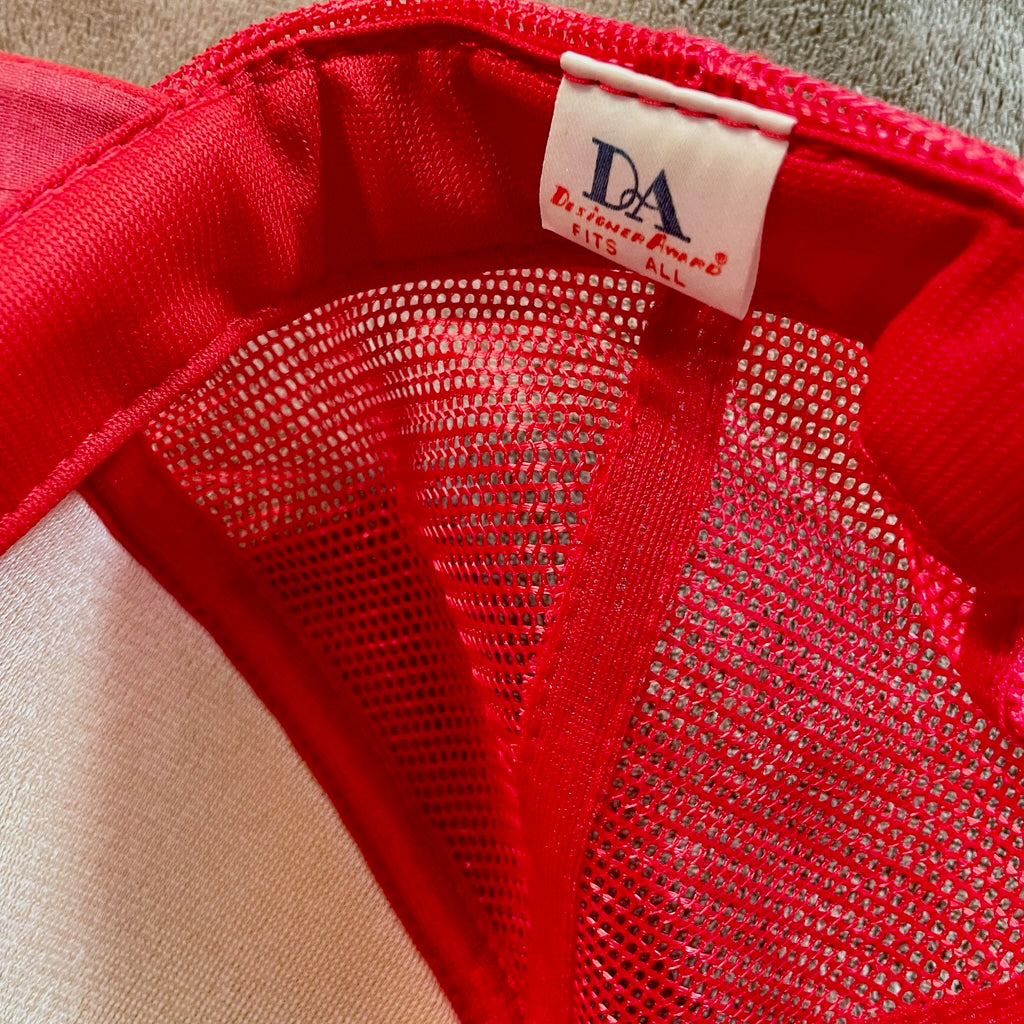 Close-up of a red garment with a visible brand label on a neutral background