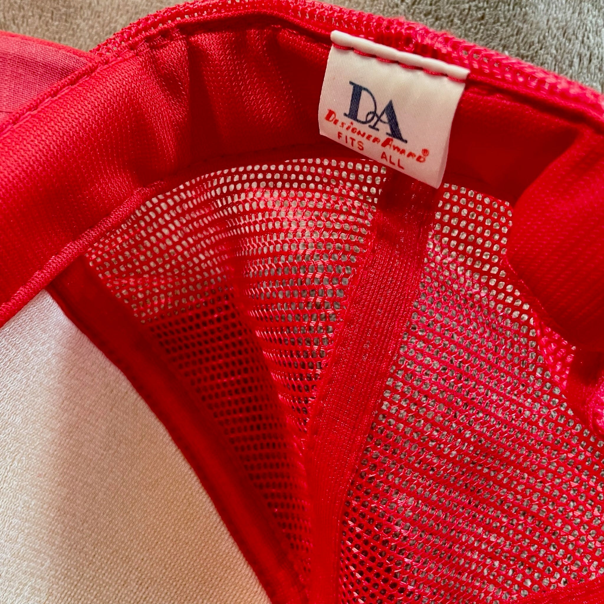 Close-up of a red garment with a visible brand label on a neutral background