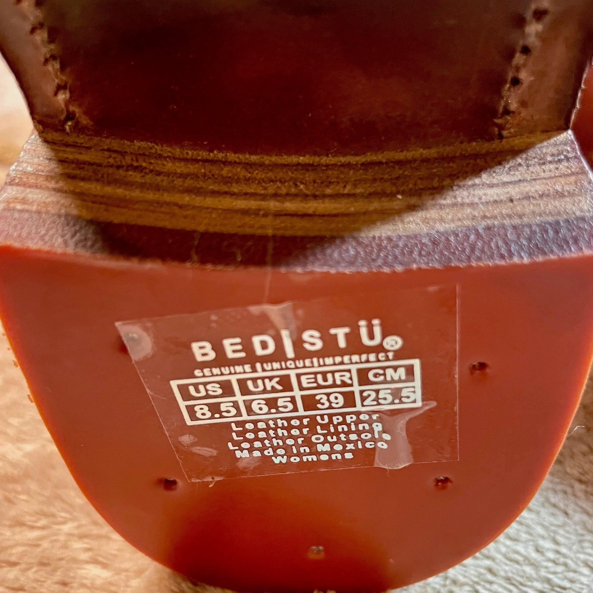 Close-up of a brown leather shoe with a Bedstö label on the sole.