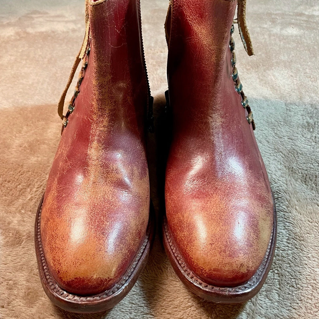Pair of brown leather boots on a textured surface