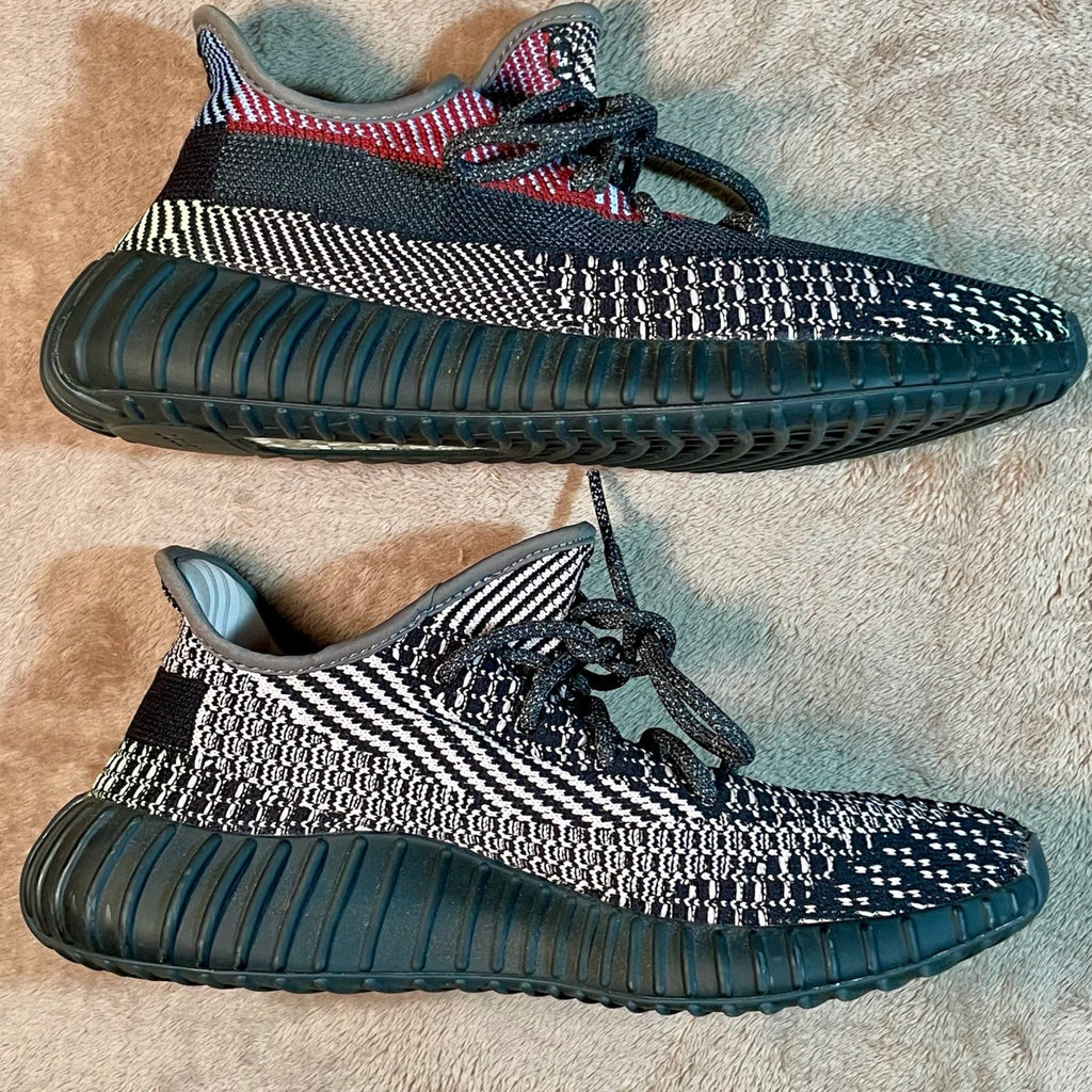 Pair of black and white sneakers on a textured surface