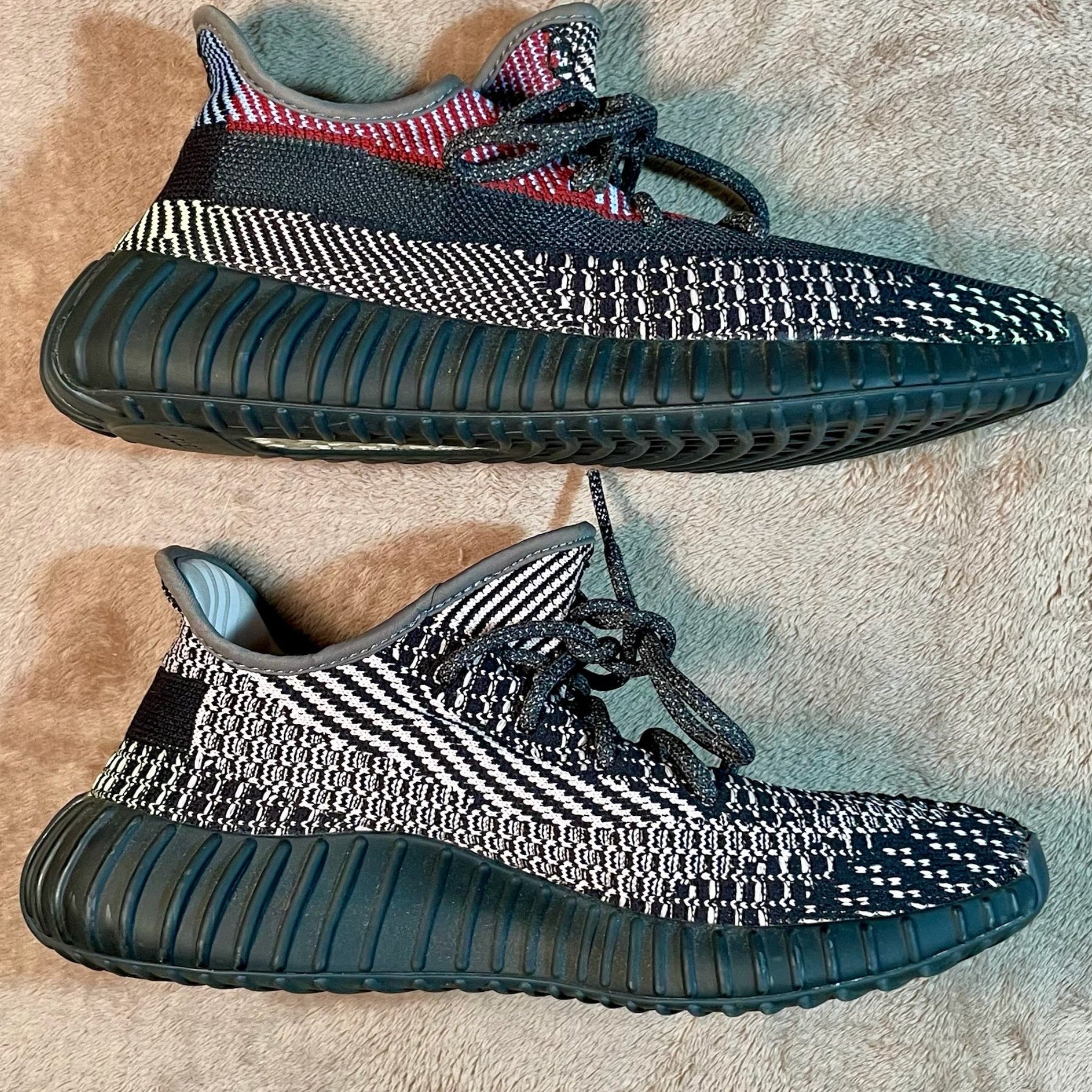 Pair of black and white sneakers on a textured surface