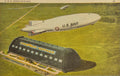 U.S. Navy airship and hangar on a grassy field with 'U.S. Navy' branding.