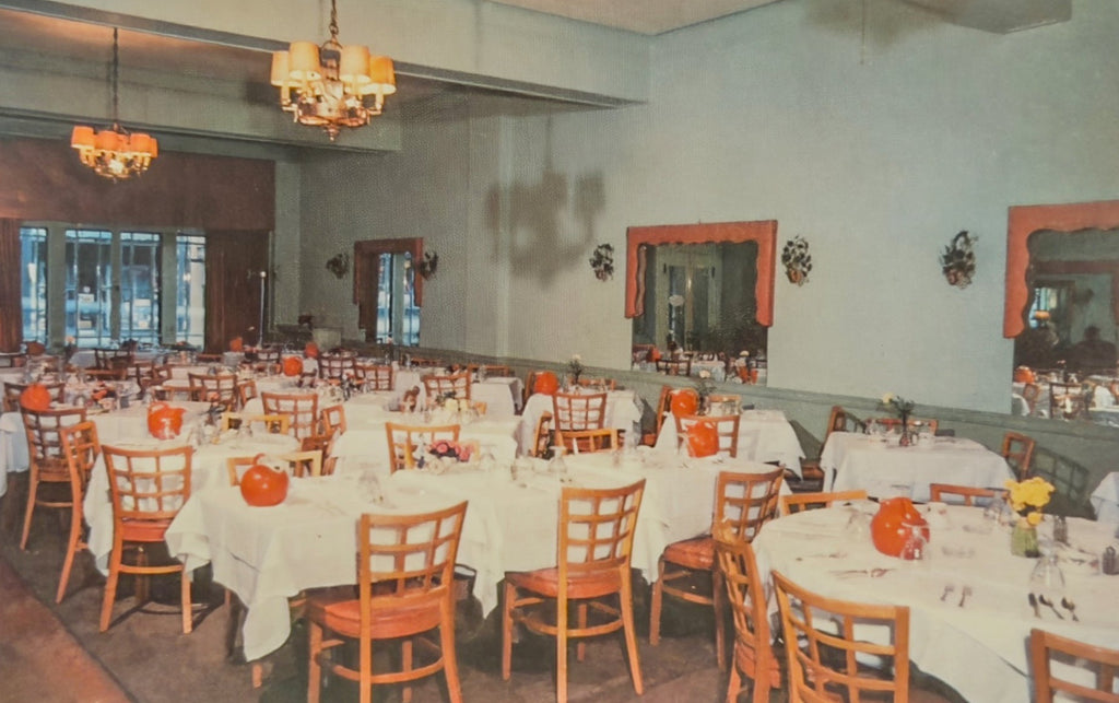 Dining room with tables set for a meal, chairs, and decorative elements.