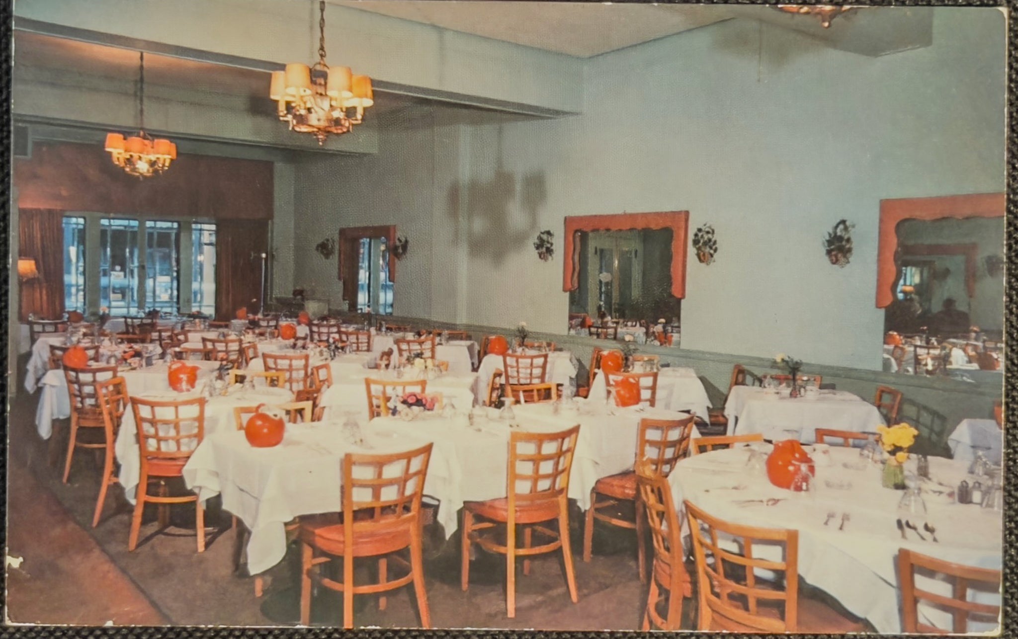 Dining room with tables set for a meal, chairs, and decorative elements.