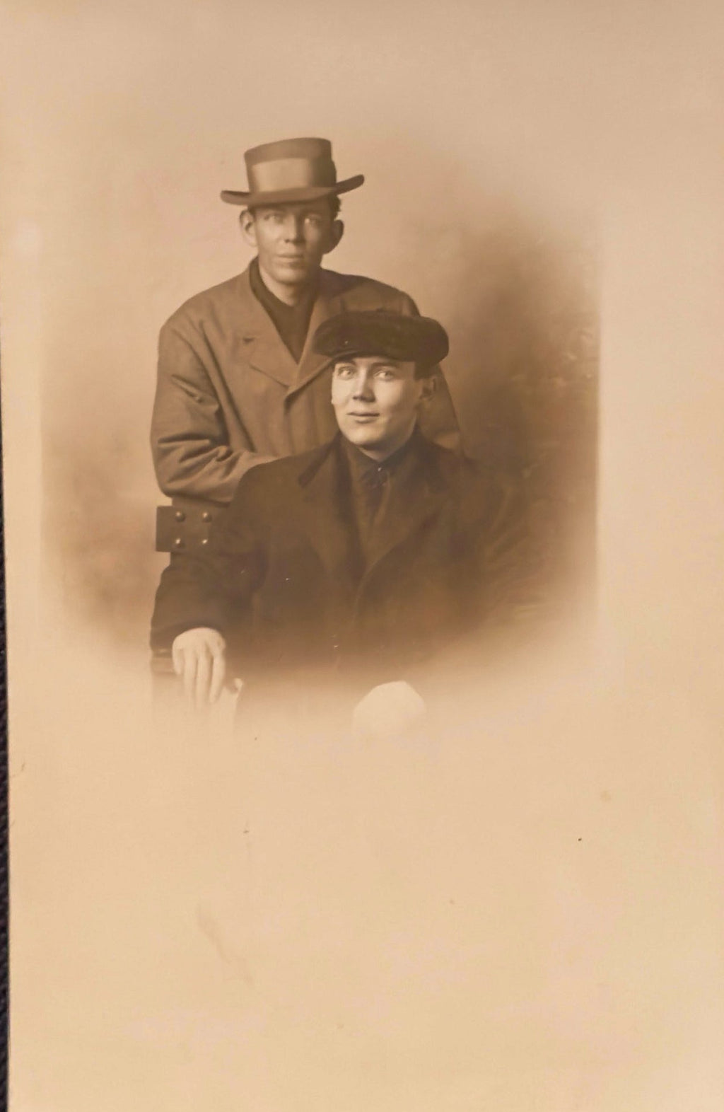 Vintage sepia-toned photograph of two men wearing hats and coats.