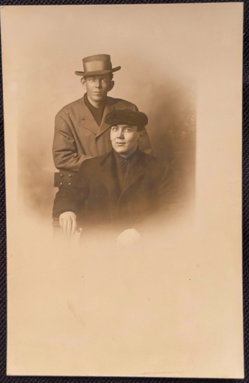 Vintage sepia-toned photograph of two men wearing hats and coats.
