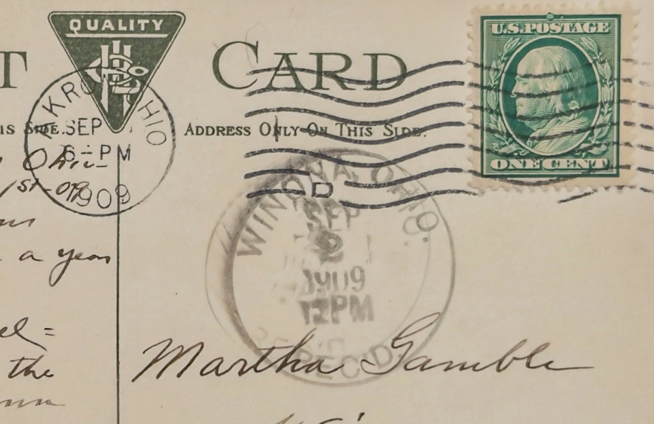 Vintage postcard with text, stamps, and a green stamp on a beige background