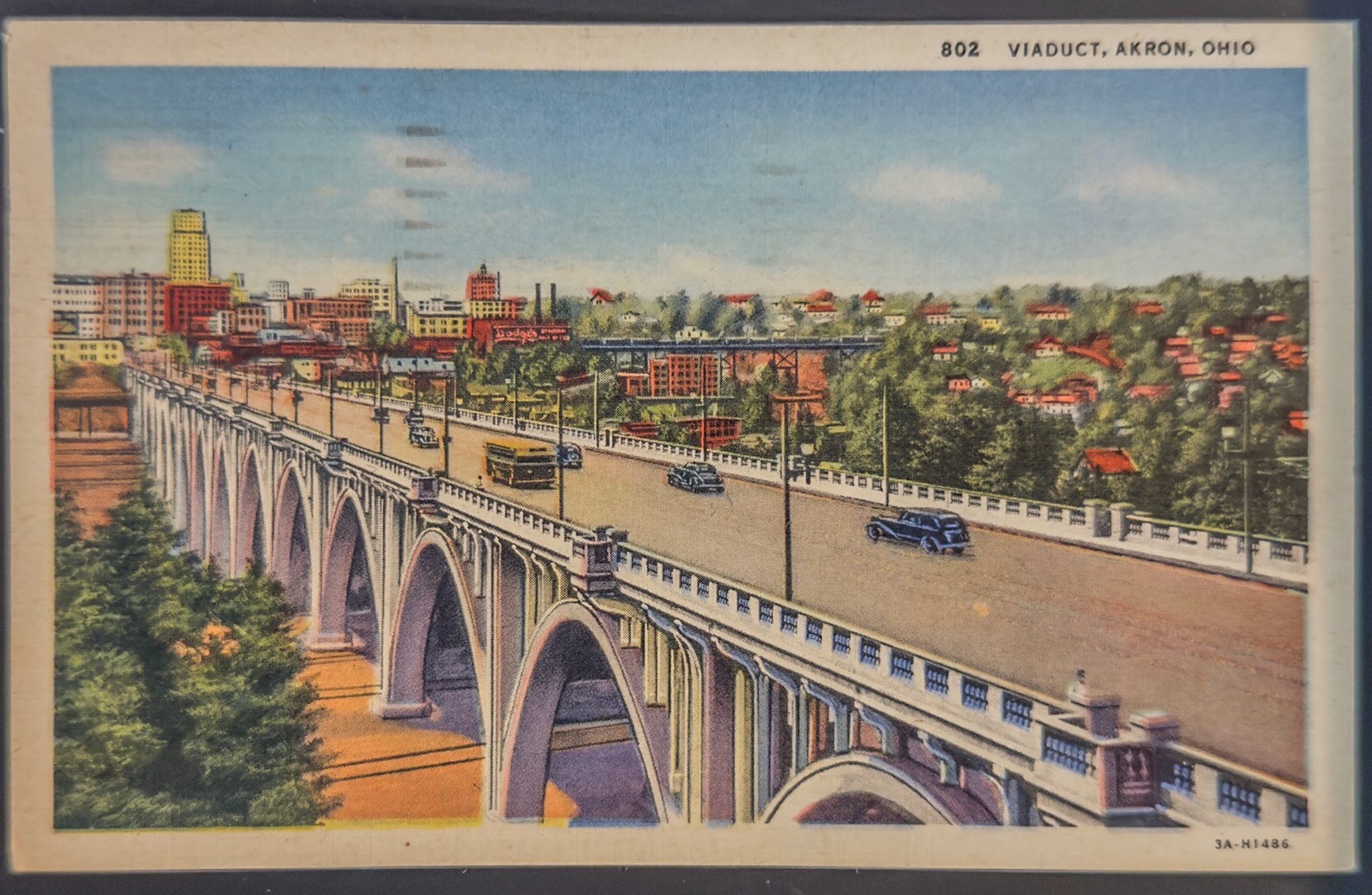 Colorful illustration of a bridge over a cityscape with buildings and trees.