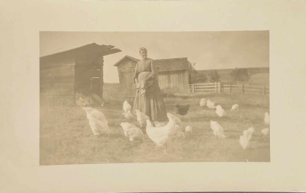 Woman standing with chickens in a rural setting