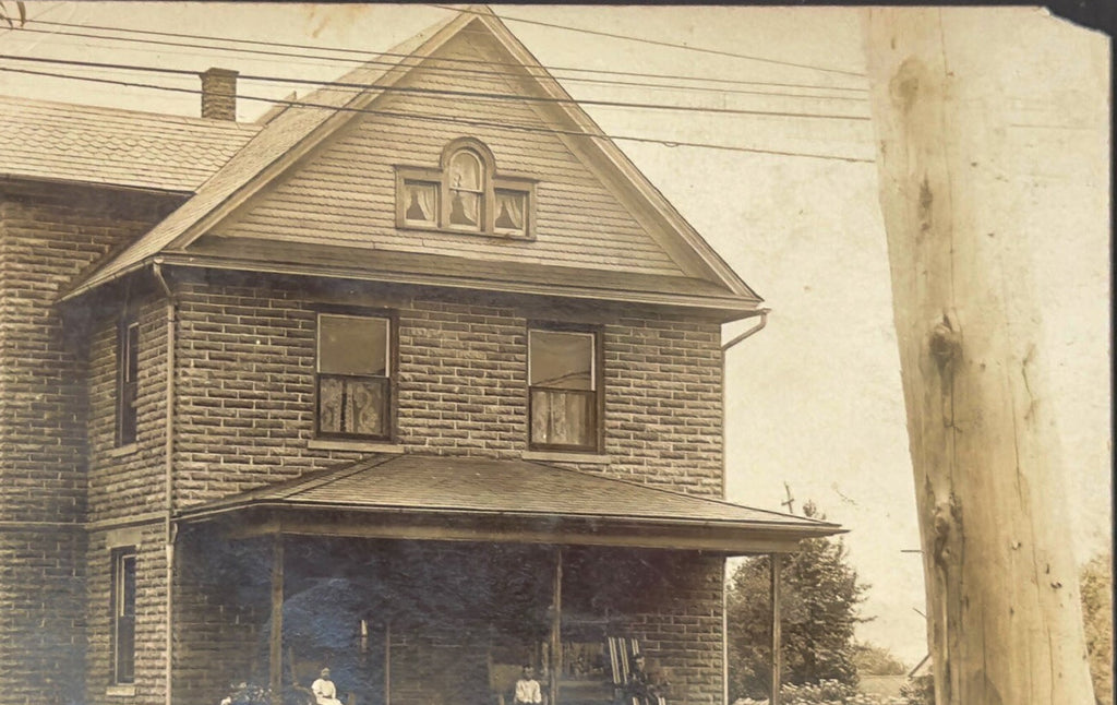 Vintage black and white photo of a two-story house with a porch