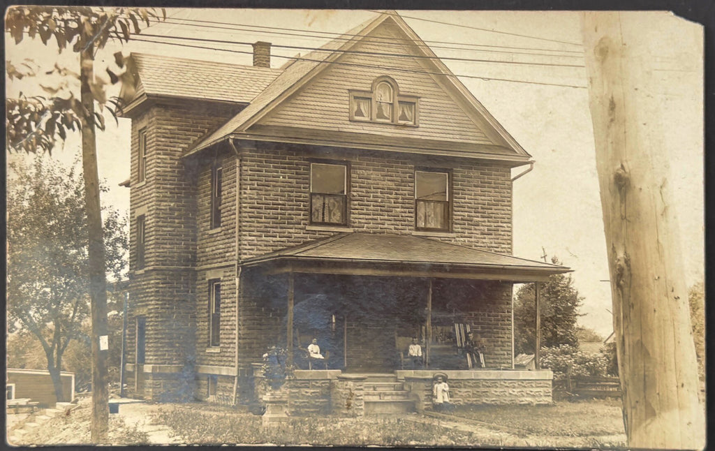 Vintage black and white photo of a two-story house with a porch