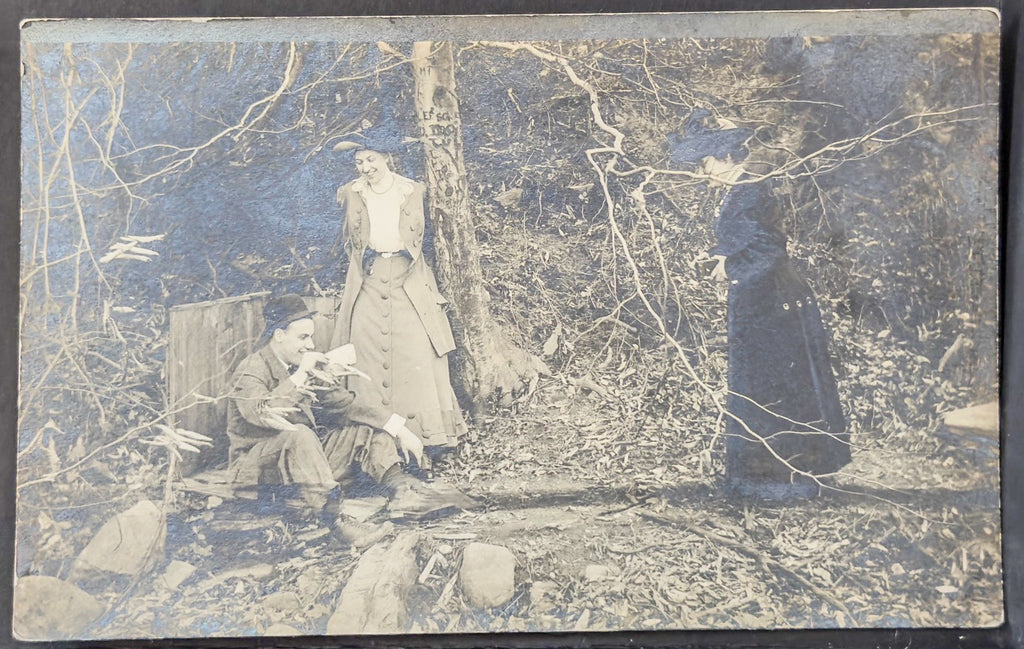 Vintage photograph of a group of people in a forest setting.