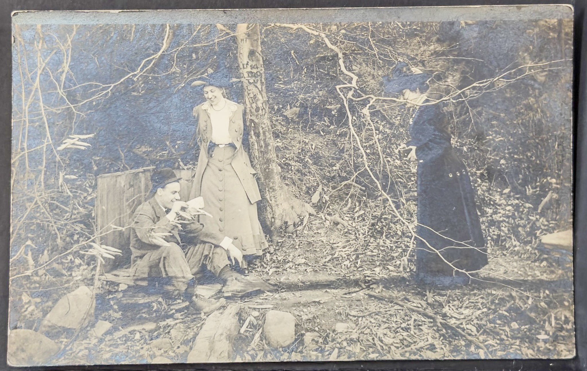 Vintage photograph of a group of people in a forest setting.