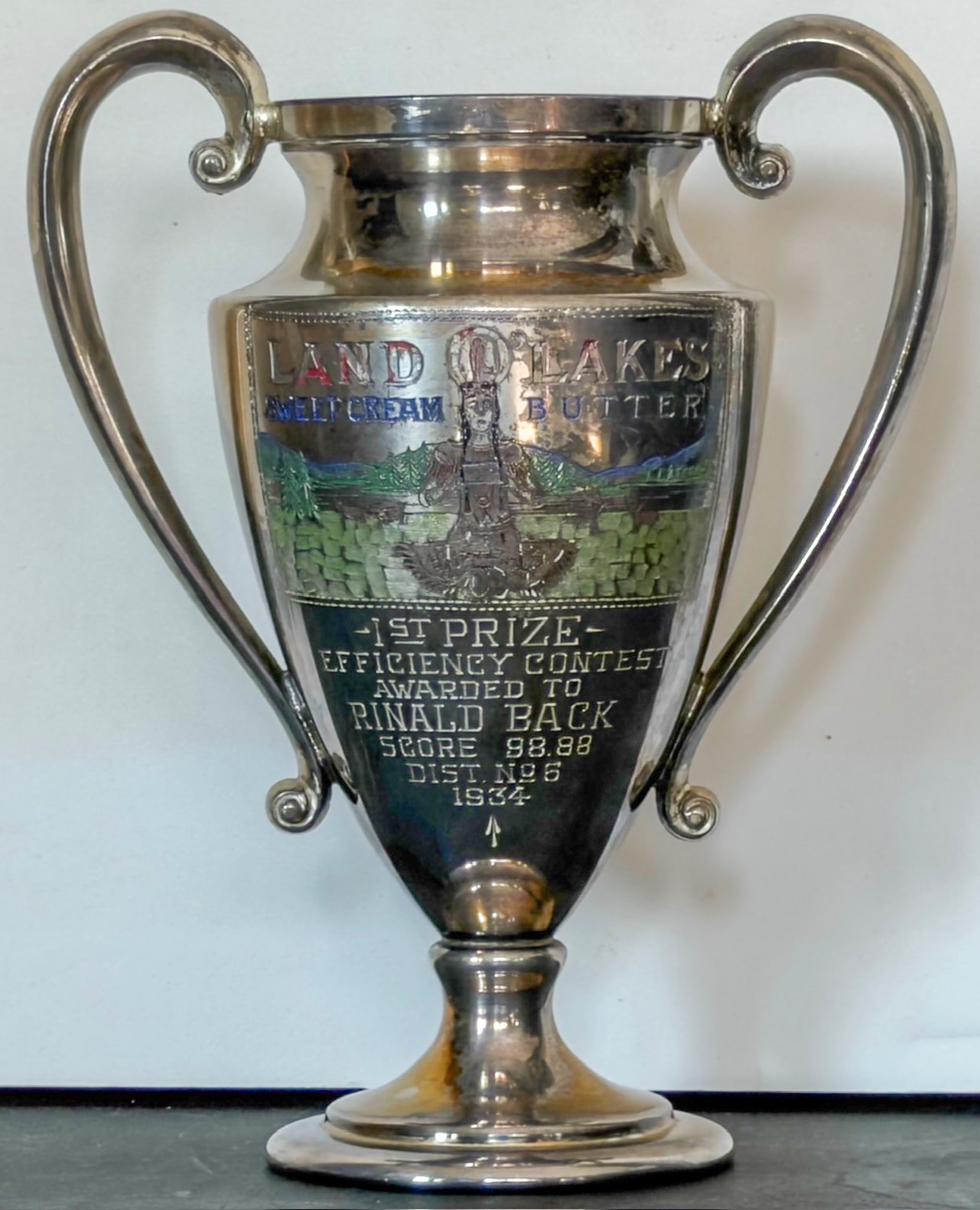 Silver trophy with engraved text on a white background