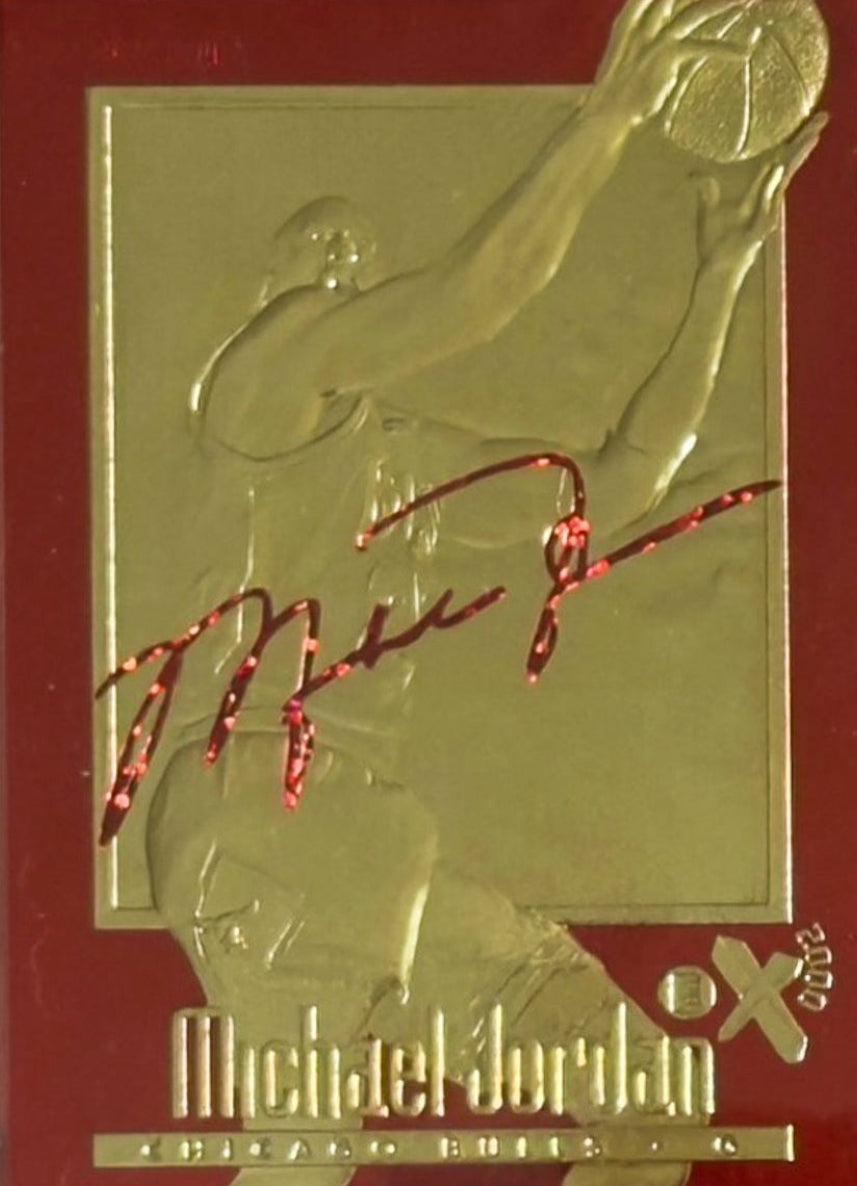 Two trading cards of Michael Jordan, one gold and one red, in protective cases with grading labels.