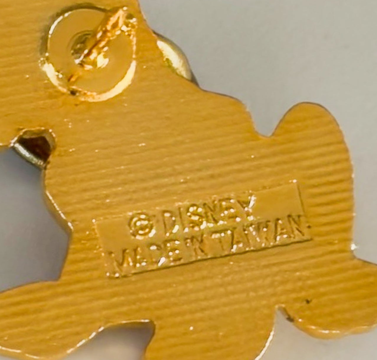 Gold-colored character-shaped object with 'Disney' branding on a light gray background