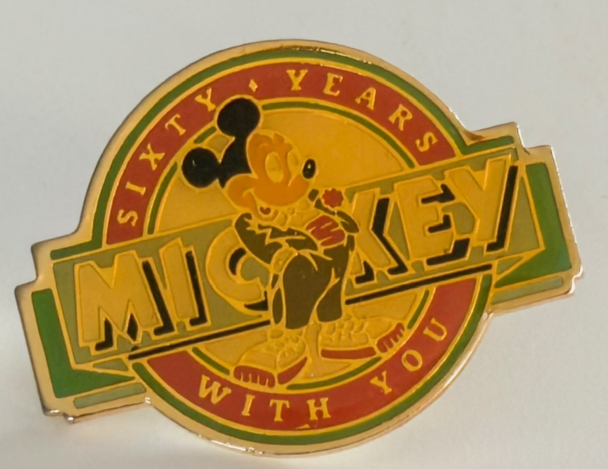 Mickey Mouse pin celebrating 60 years with text on a white background