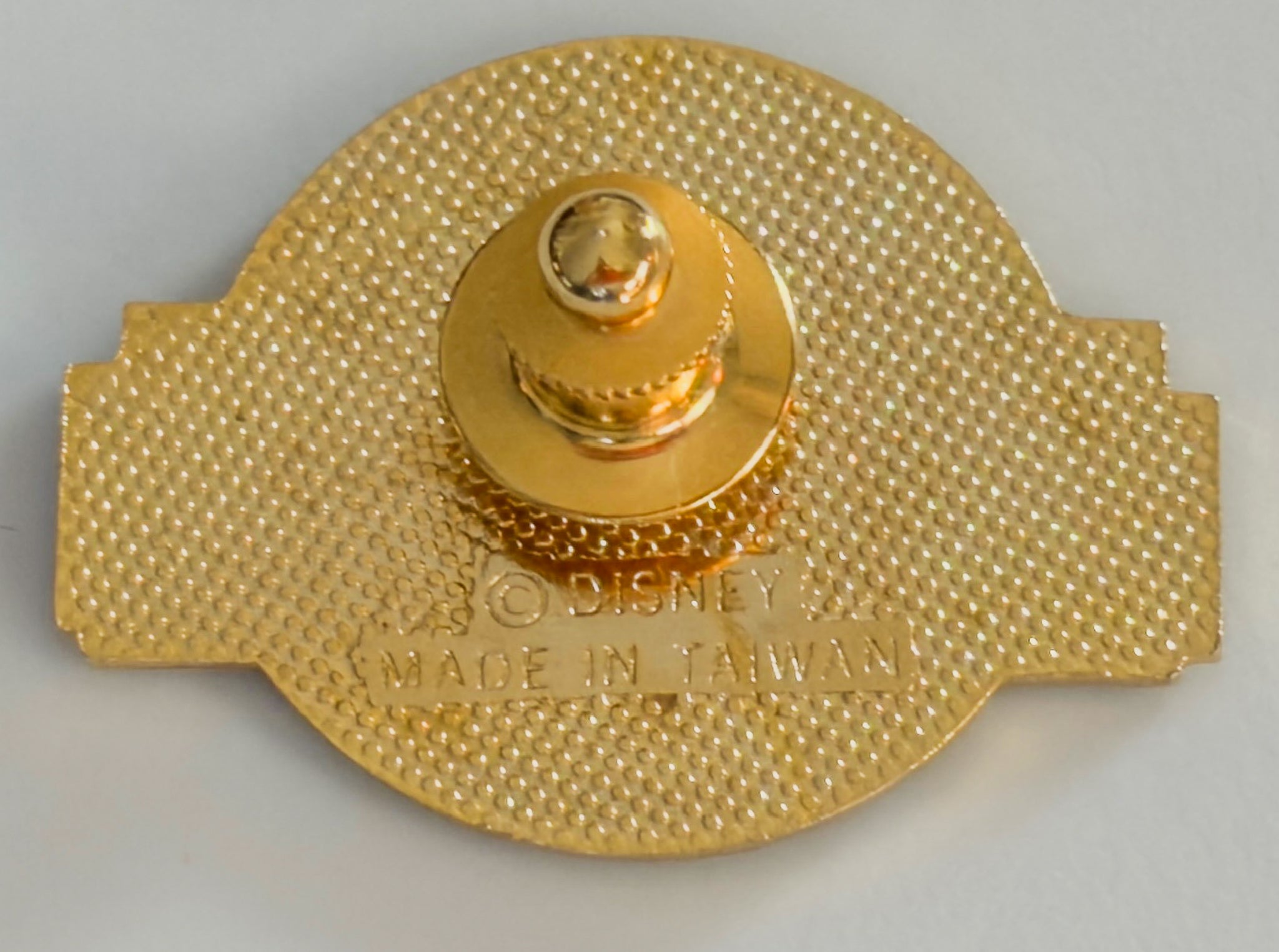 Gold-colored object with 'Disney' branding on a gray background