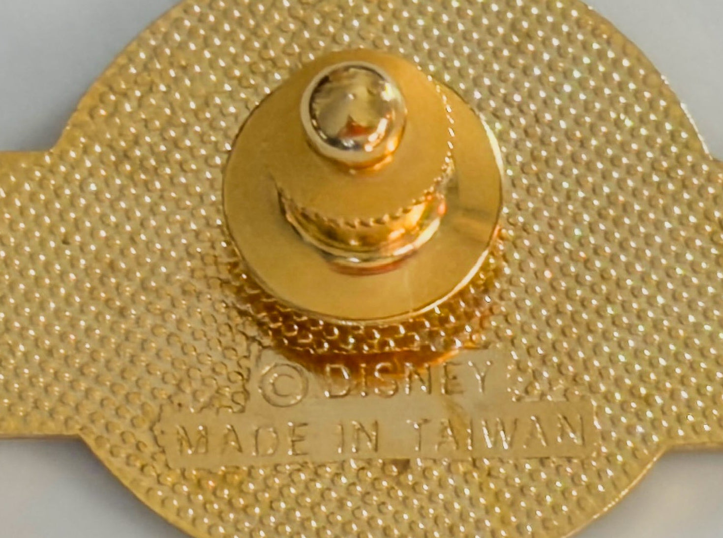 Gold-colored object with 'Disney' branding on a gray background