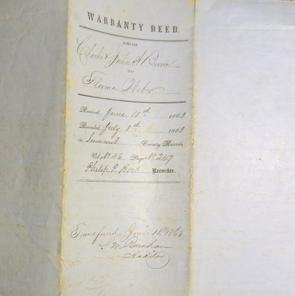 Warranty deed document on a textured surface