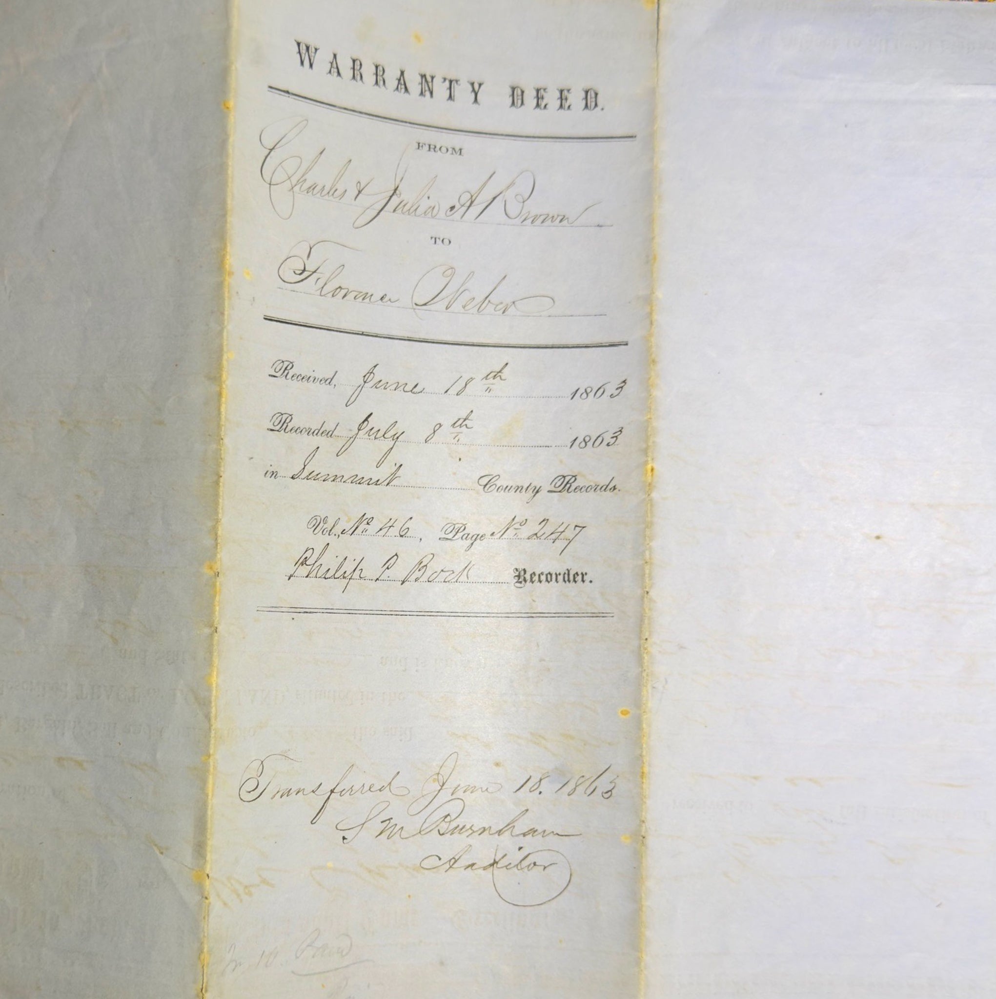 Warranty deed document on a textured surface