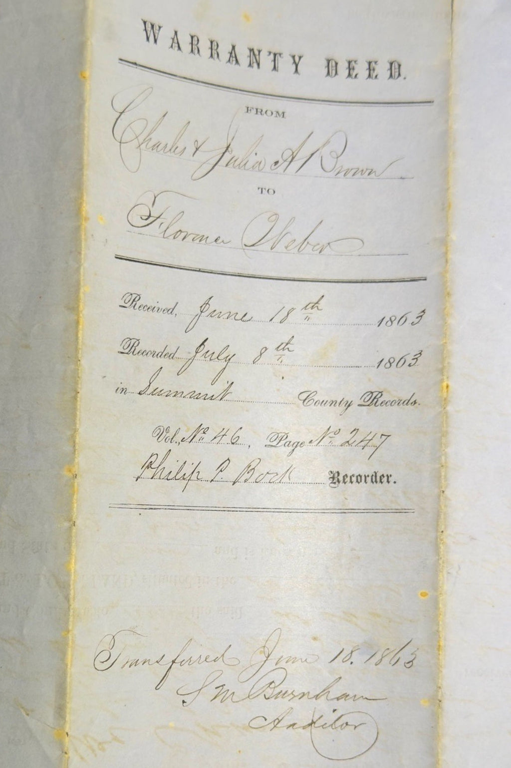 Warranty deed document on a textured surface